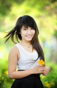 Beautiful smiling girl holding flower